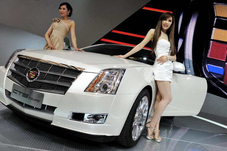 Models pose by a Cadillac CTS coupe at the Shanghai Auto Show in Shanghai on April 19, 2011