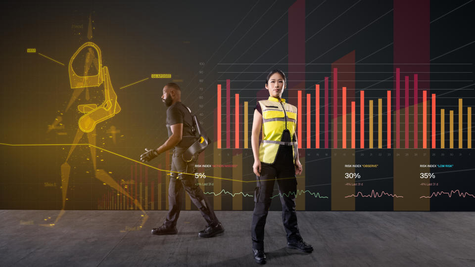two models wearing the exosuit and vest standing against a cgi background with a bunch of graphs and stuff? I dunno. Either way, hope your day&#39;s going well.