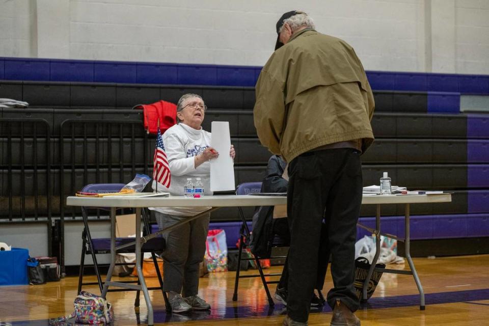 Election judge Karen Clapper talked with Larry Coomce of Raytown as he checked into vote at Raytown Central Middle School on Tuesday, April 2, 2024. Jackson County voters went to the polls to decide on many races but most notably Question 1, which would authorize tax funding to help pay for a new Royals stadium in the Crossroads and renovations to Arrowhead Stadium.