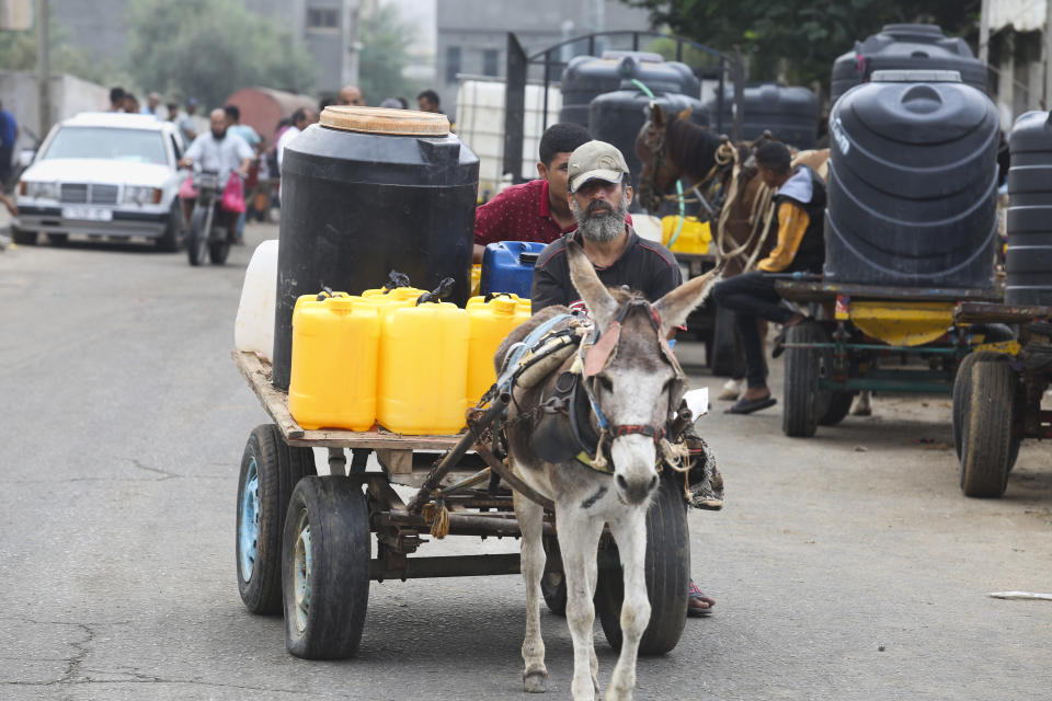 Palestinians arrive to collect drinking water during the ongoing Israeli bombardment of the Gaza Strip in Rafah on Saturday, Oct. 28, 2023. (AP Photo/Hatem Ali)