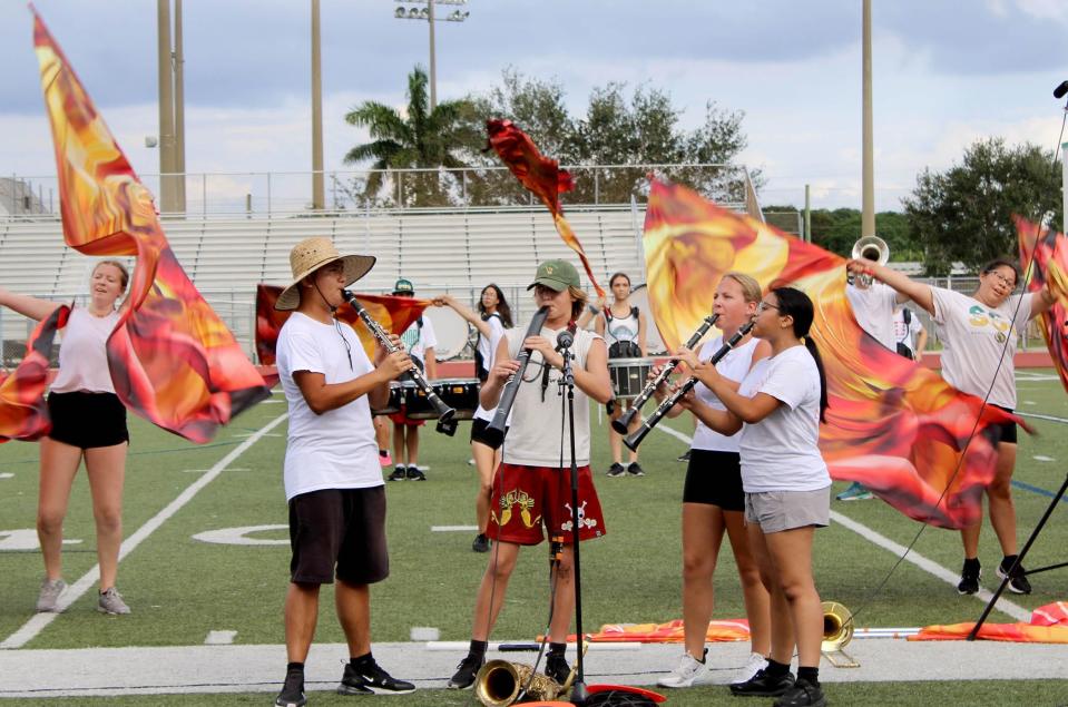 Jupiter High School marching band members Kevin Espinoza Martinez (left), Collin Smith, Nina Ravaschieri and Jessica Vicente practice at the school.