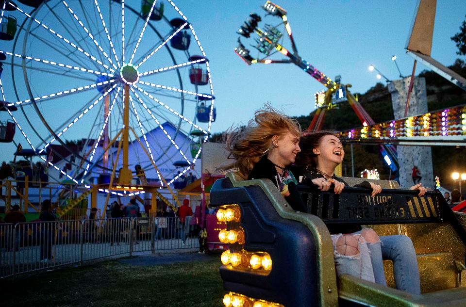 Fairgoers share a laugh as they ride on "The Sizzler" ride at the Fairfield County Fair on Oct. 11, 2022 in Lancaster, Ohio.