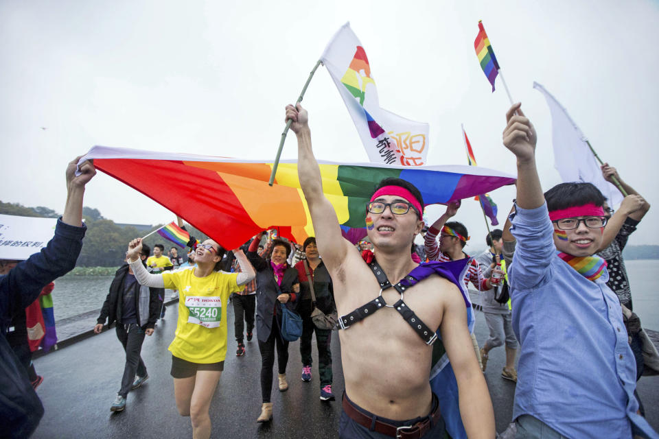 FILE - Gay rights activists run with a rainbow flag during the Hangzhou International Marathon in Hangzhou in eastern China's Zhejiang province on Nov. 1, 2015. A LGBT advocacy group in China that has spearheaded many of the country's legal cases pushing for greater rights, announced on social media Thursday, Nov. 5, 2021, it is halting its work for the foreseeable future. (Chinatopix Via AP, File)