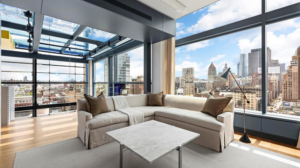 The penthouse has floor-to-ceiling windows and a glass roof.