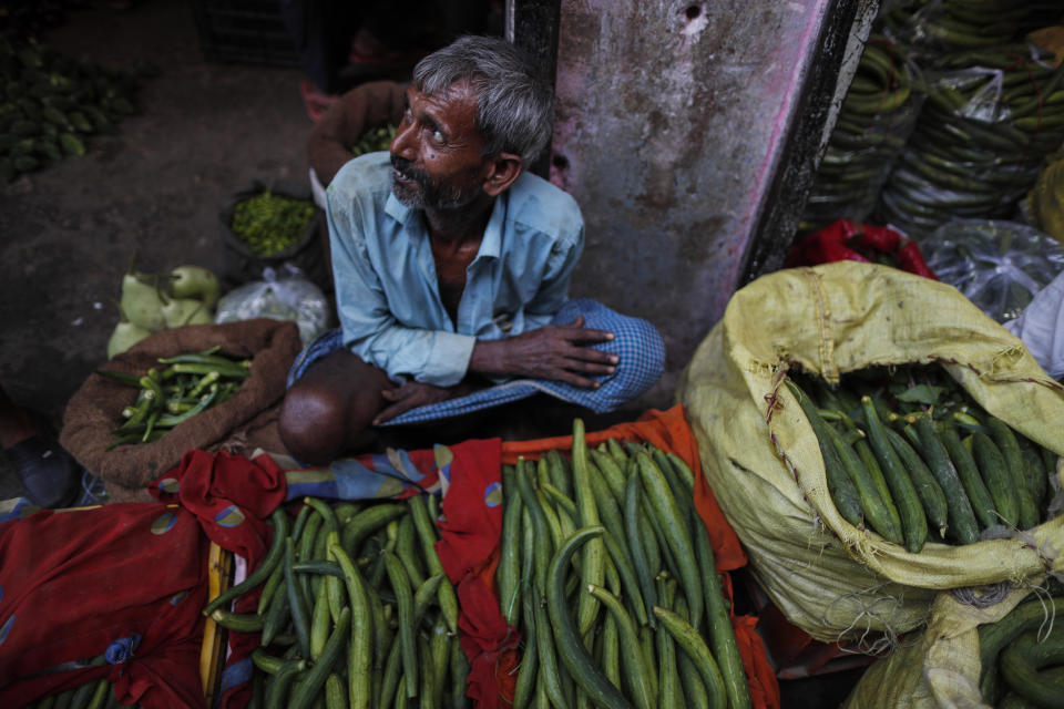 A farmer waits for customers at a wholesale vegetable market in Prayagraj, Uttar Pradesh state, India, Sunday, July 25, 2021. (AP Photo/Rajesh Kumar Singh)