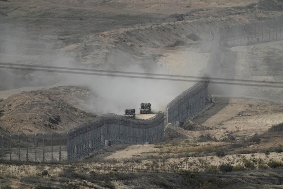 Israeli armoured vehicles drive along the fence around the Gaza Strip, as seen from southern Israel, Thursday Nov. 9, 2023. (AP Photo/Leo Correa)