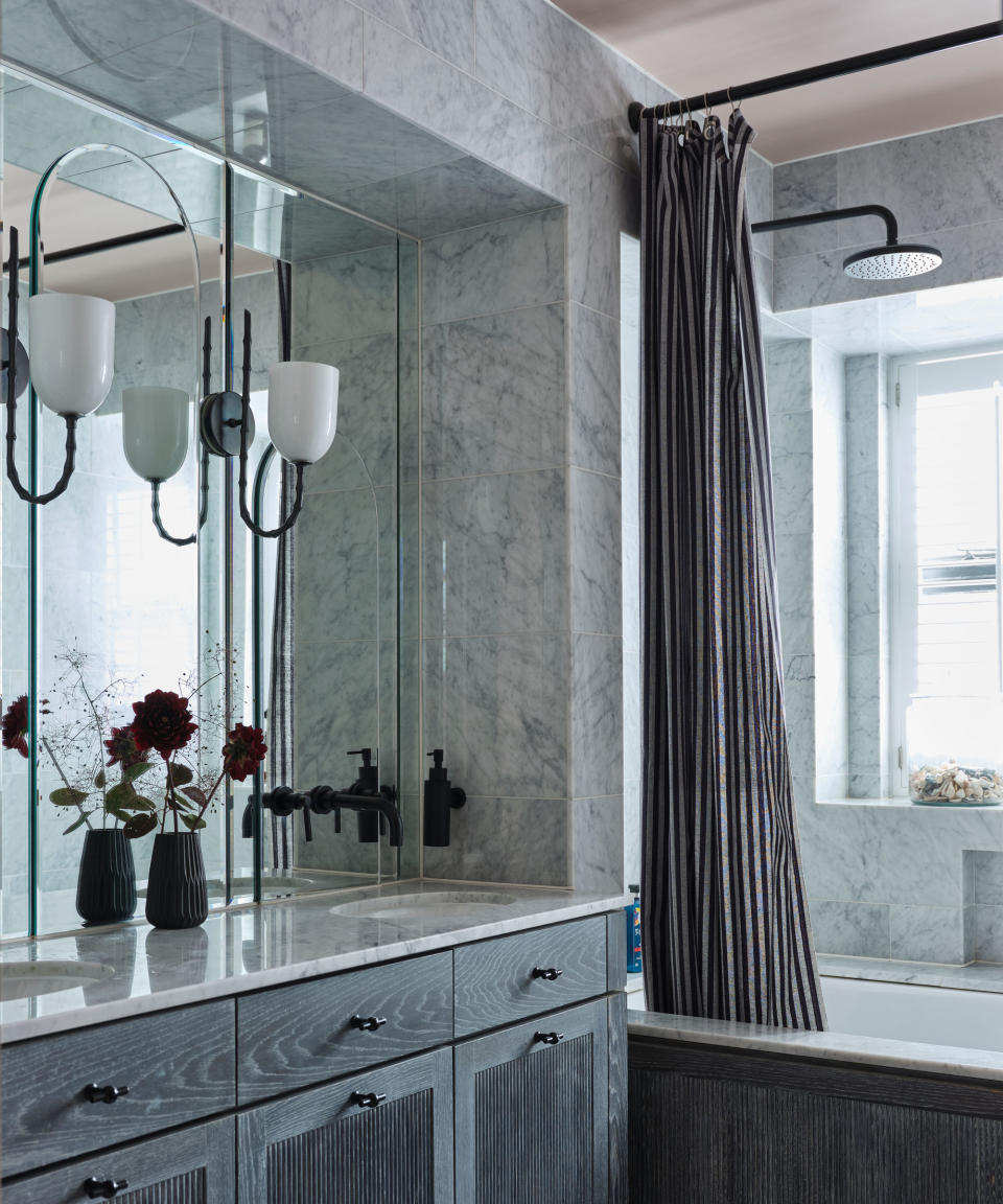 blue bathroom with mirror, bath, shower and black hardware