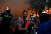 <p>Firefighters, soldiers and local residents carry a hose as a wildfire burns in the town of Rafina, near Athens, Greece, July 23, 2018. (Photo: Costas Baltas/Reuters) </p>