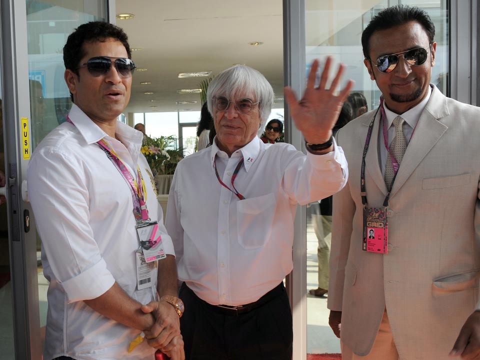 Indian cricketer Sachin Tendulkar (L), Indian Bollywood star Gulshan Grovar (R) and President and CEO of Formula One Management and Formula One Administration Bernie Ecclestone (C) pose for media in paddock prior to the Formula One's Indian Grand Prix at the Buddh International circuit in Greater Noida on October 30, 2011. AFP PHOTO/ Prakash SINGH (Photo credit should read PRAKASH SINGH/AFP/Getty Images)