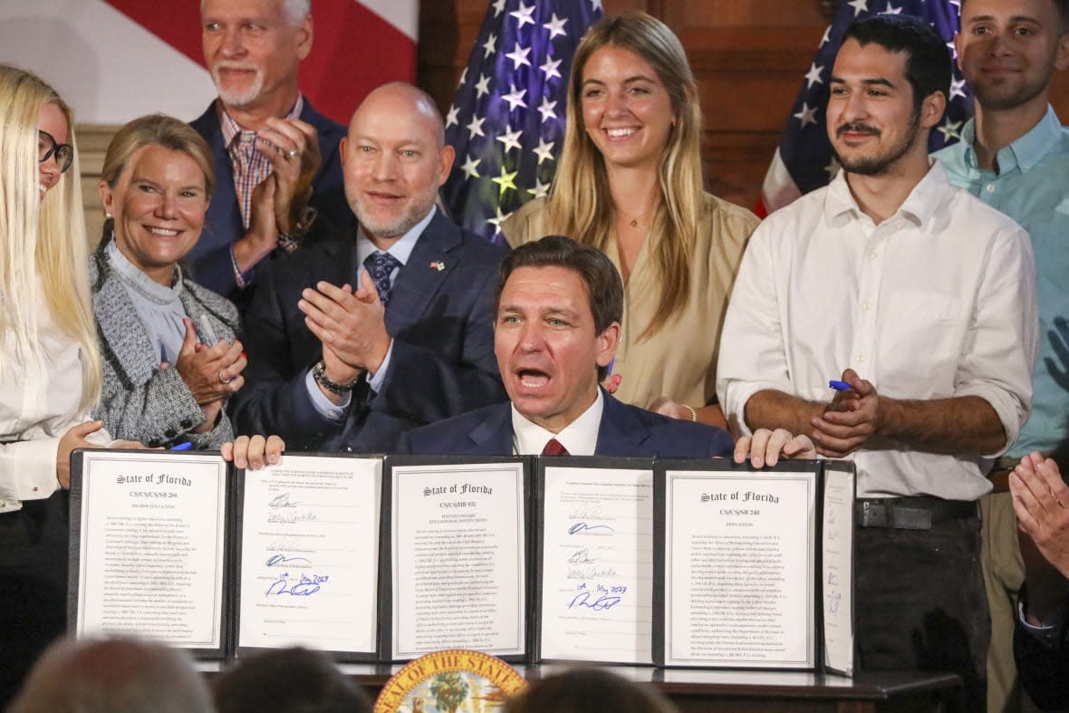 Florida Gov. Ron DeSantis signs legislation on Monday, May 15, 2023, banning state funding for diversity, equity, and inclusion programs at Florida’s public universities, at New College of Florida in Sarasota, Fla. (Douglas R. Clifford/Tampa Bay Times via AP)