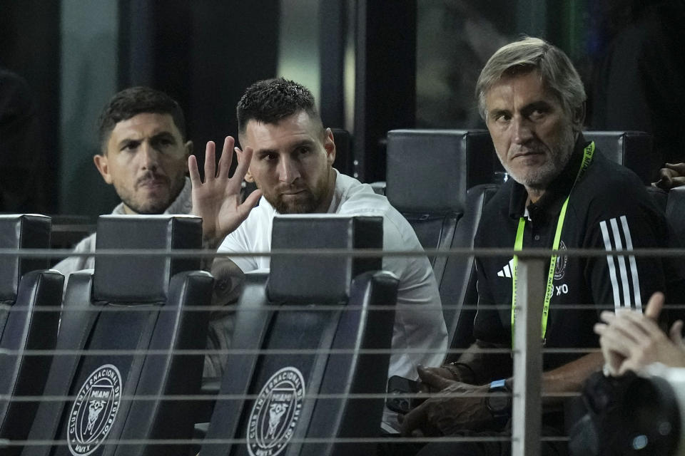 Inter Miami forward Lionel Messi, second from left, waves from his box as he watches from the sideline during the second half of an MLS soccer match between Inter Miami and Charlotte FC, Wednesday, Oct. 18, 2023, in Fort Lauderdale, Fla. (AP Photo/Rebecca Blackwell)