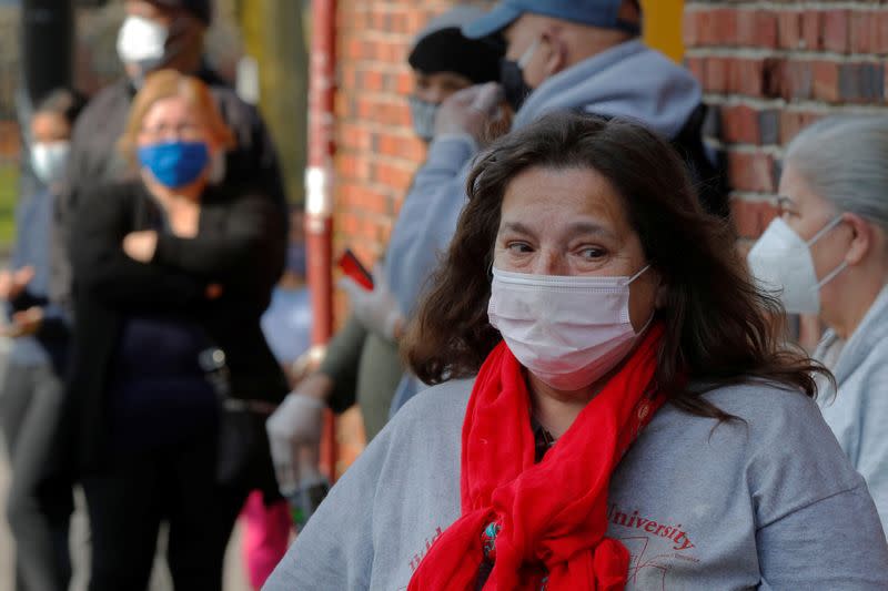 Residentes esperan en una fila para recoger alimentos gratis del Ejército de Salvación en medio de la epidemia de coronavirus en Lynn, Massachusetts