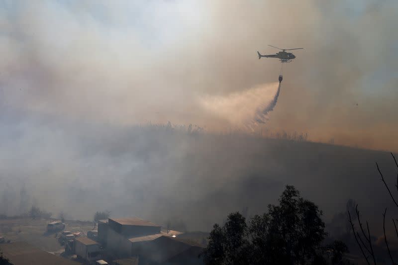 A helicopter works to contain a fire in Valparaiso