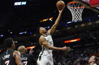 Milwaukee Bucks forward Giannis Antetokounmpo (34) drives tp the basket over Miami Heat guard Kyle Lowry (7) and forward P.J. Tucker (17) during the first half of an NBA basketball game, Wednesday, Dec. 8, 2021, in Miami. (AP Photo/Marta Lavandier)