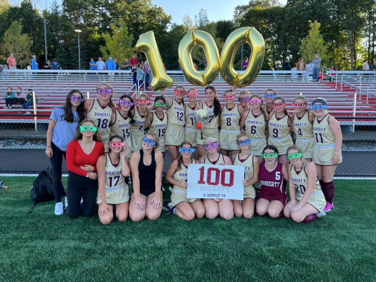 Doherty junior Hannah Murray, center, with tiara and flowers, celebrates scoring her 100th career point surrounded by teammates during Friday's win over South at South High.