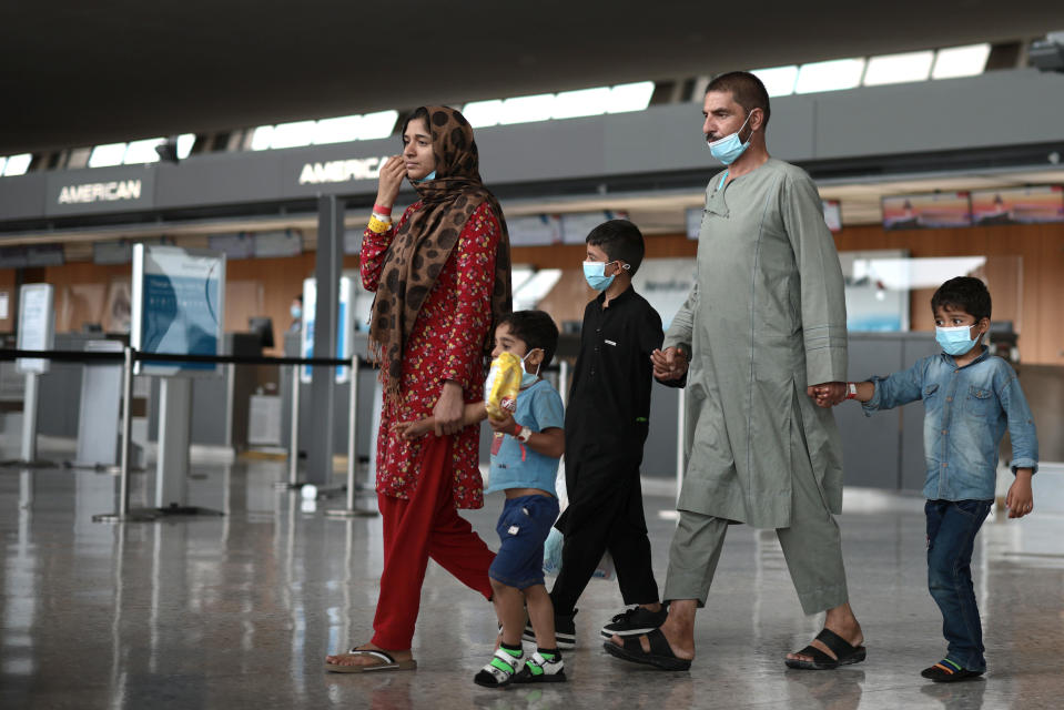 Refugees are led through the departure terminal to a bus at Dulles International Airport after being evacuated from Kabul following the Taliban takeover of Afghanistan on Aug. 31, 2021, in Dulles, Virginia. / Credit: Getty Images