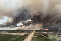 <p>An image taken through a window shows smoke rising from mutual aid wildfire HTZ001 in the High Level Forest Area, which originated from the Northwest Territories in 2023 but flared due to strong winds, near Indian Cabins, Alberta, Canada May 10, 2024.</p> 