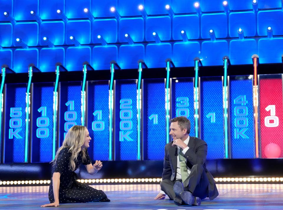 Christiana Trapani, co-owner with her husband, Nic Trapani, of Door County Candle Co., talks with host Chris Hardwick, right, on the NBC game show "The Wall." The Trapanis are the contestants on the Season 5 premiere of the show airing April 11.