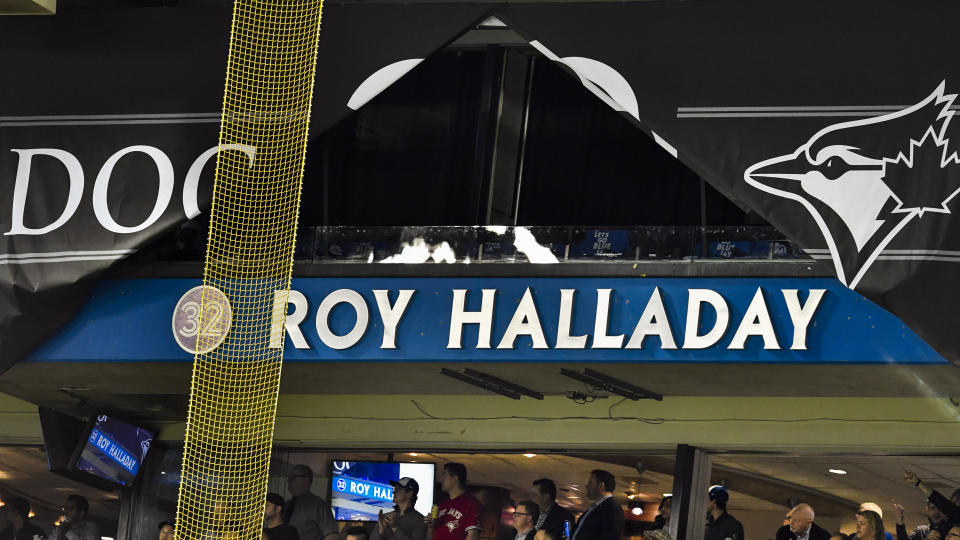 TORONTO, ON - MARCH 29: Roy Halliday's name is revealed, newly appointed on a stadium fascia in a ceremony honoring the late Jay's pitcher before the MLB season game between the New York Yankees and the Toronto Blue Jays at Rogers Centre in Toronto, ON., Canada March 29, 2018. The Blue Jays also retired his No. 32 on opening day. Jays players will wear a no. 32 patch on their jerseys throughout the season in tribute to Halladay. Halladay, nicknamed 'Doc' who spent 12 seasons as a pitcher with the Jays, died in November 2017 when his personal plane crashed into the Gulf of Mexico near Tampa. He was 40 years old. Halladay joins Robero Alomar (no. 12) as the only 2 players in Jays history to have their jersey numbers retired. (Photo by Jeff Chevrier/Icon Sportswire via Getty Images)