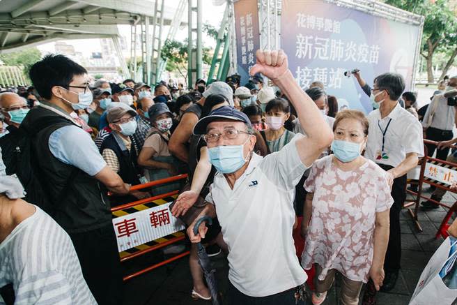 民眾13日冒雨前往場館接種疫苗；由於每日施打人數從六千人驟然上升至一萬三千人，場館外排隊人龍塞爆，民眾不滿動線紊亂，抱怨連連。（郭吉銓攝）