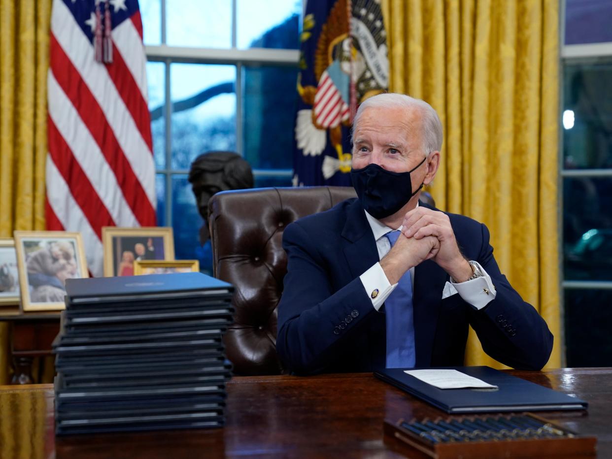 Joe Biden waits to sign his first executive order in the Oval Office of the White House  (AP)