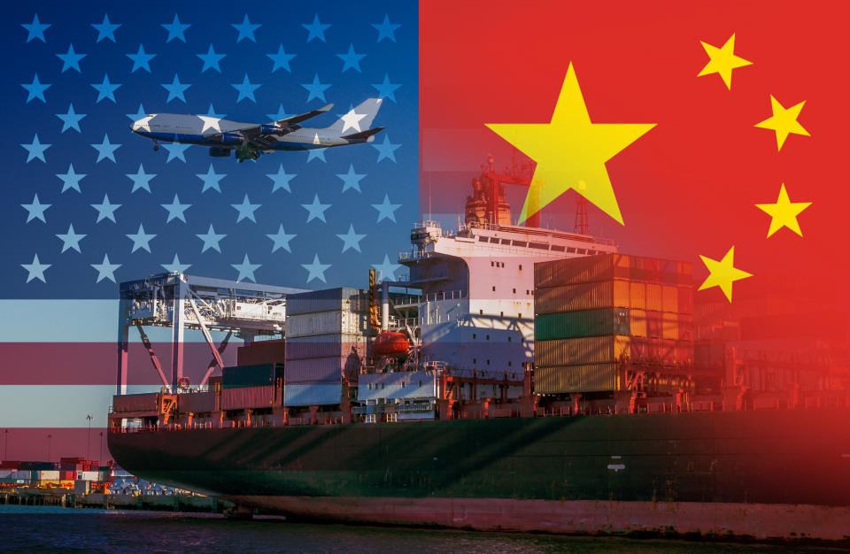 The American and Chinese flags imposed over shipping containers at a port with a plane flying over representing trade between the two countries.