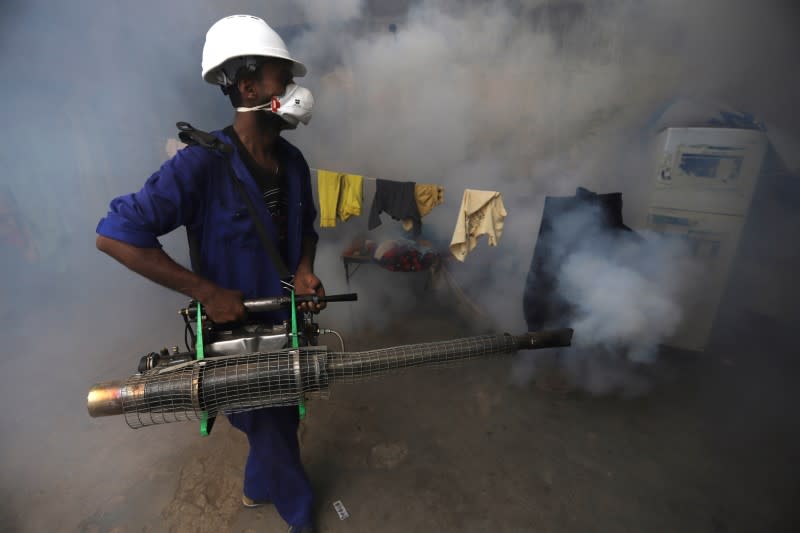 Health worker fumigates a residential area to curb the spread of dengue fever in Hodeidah