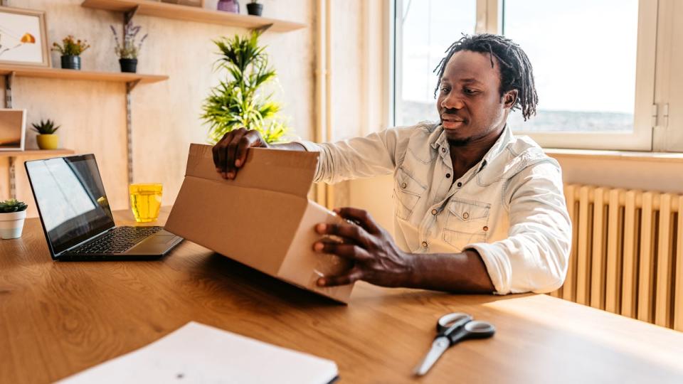 Man opens package at desk