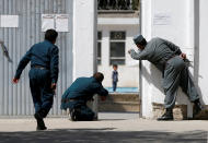 <p>Polizisten wollen nach einem Selbstmordanschlag in Afghanistan einen kleinen Jungen in Sicherheit bringen, der sich nach wie vor im Gefahrengebiet befindet. Nahe einer schiitischen Moschee hatte sich ein Islamist in die Luft gesprengt. (Bild: REUTERS/Omar Sobhani) </p>
