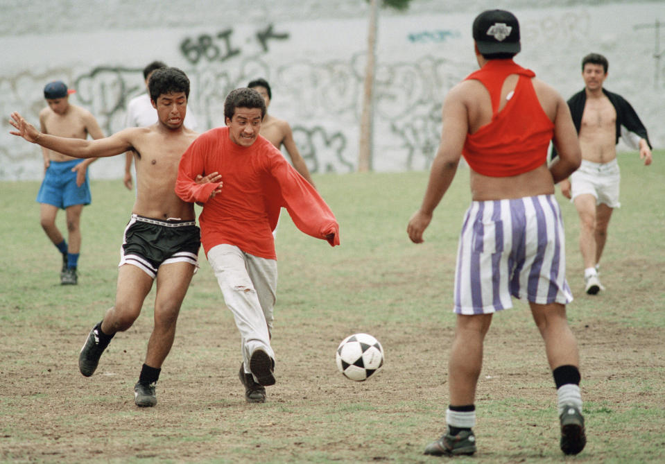 FILE - Youths play soccer at a park on Saturday, April 17, 1993 in the Korea town section of Los Angeles. Korea town, hit hard during the rioting in Los Angeles in 1992, appeared as normal following the verdicts in the Rodney King civil rights case, handed down earlier in the day. (AP Photo/Paul Sakuma, File)