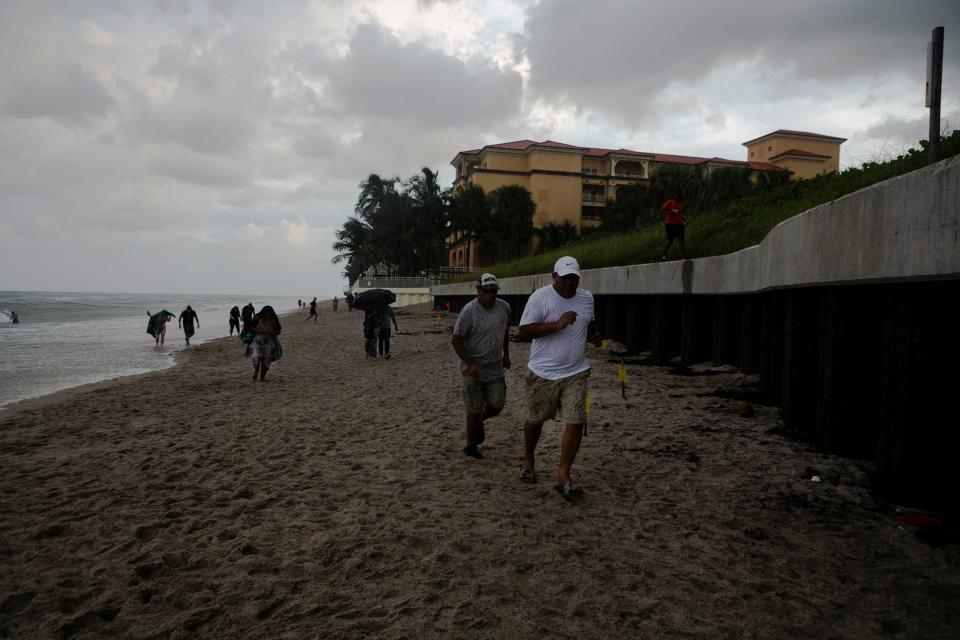 People run from the rain in Lantana Beach, Florida (Picture: Getty)