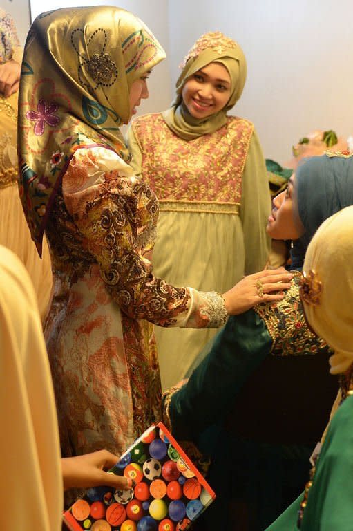 Muslimah World pageant contestant Dayangku Rabiatul Adawiyah (L) of Brunei talks to other contestants while they prepare backstage for the grand final of the contest in Jakarta on September 18, 2013. The finale of a beauty pageant exclusively for Muslim women will take place in the Indonesian capital Wednesday, in a riposte to the Miss World contest in Bali that has drawn fierce opposition