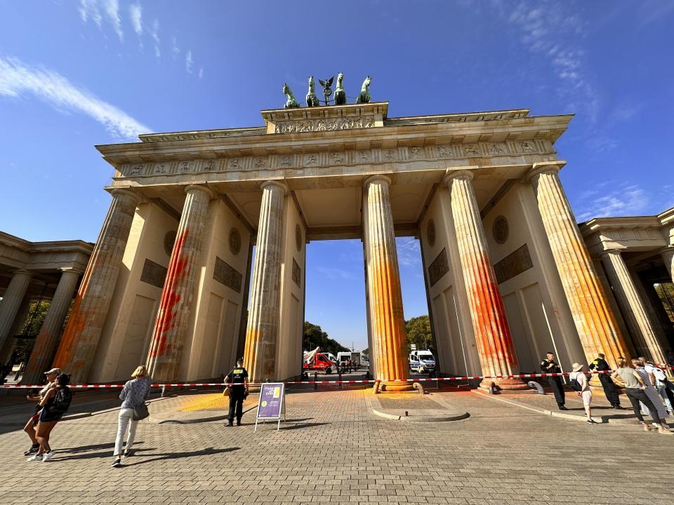 FILE - Members of the climate protection group Last Generation have sprayed the Brandenburg Gate with orange paint in Berlin, Germany, on Sept. 17, 2023. Berlin's Brandenburg Gate will have to be cleaned at greater effort and expense than previously thought after climate activists sprayed orange paint on the German capital's signature landmark earlier this month, a company that manages official buildings in the city said Thursday, Sept. 28, 2023.(Paul Zinken/dpa via AP)
