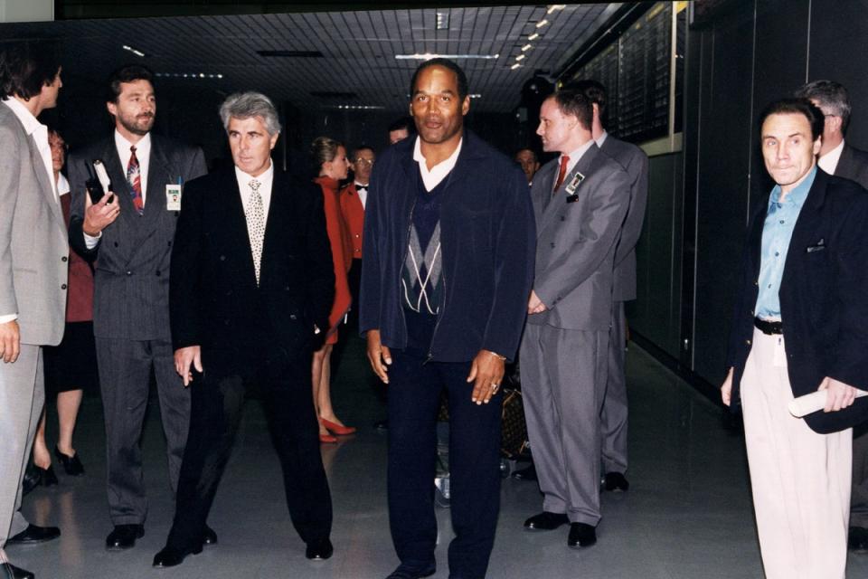 Former American football player O.J. Simpson arriving in England with British publicist Max Clifford