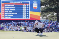 Jason Kokrak checks the lie on the 18th green in front of the leaderboard during the final round of the Houston Open golf tournament Sunday, Nov. 14, 2021, in Houston. (AP Photo/Michael Wyke)