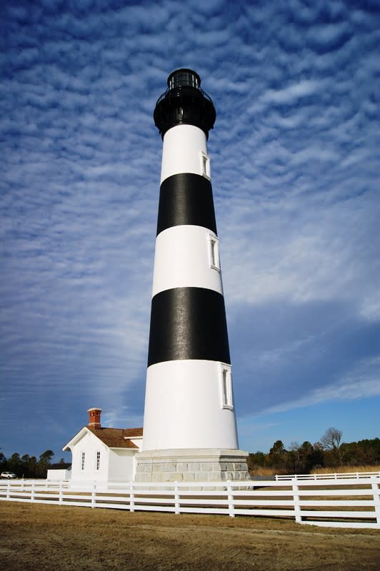 FILE - This Jan. 10, 2013 image provided by the National Park Service shows the renovated Bodie Island Lighthouse on North Carolina's Outer Banks. The National Park Service charges admission to climb both the Cape Hatteras and Bodie island lighthouses. But nothing stops visitors from looking at the lighthouses and admiring them from the ground. Bodie Island just underwent a $5 million makeover and was opened to the public in April for the first time in its 141-year history. (AP Photo/National Park Service, Cyndy Holda, File)