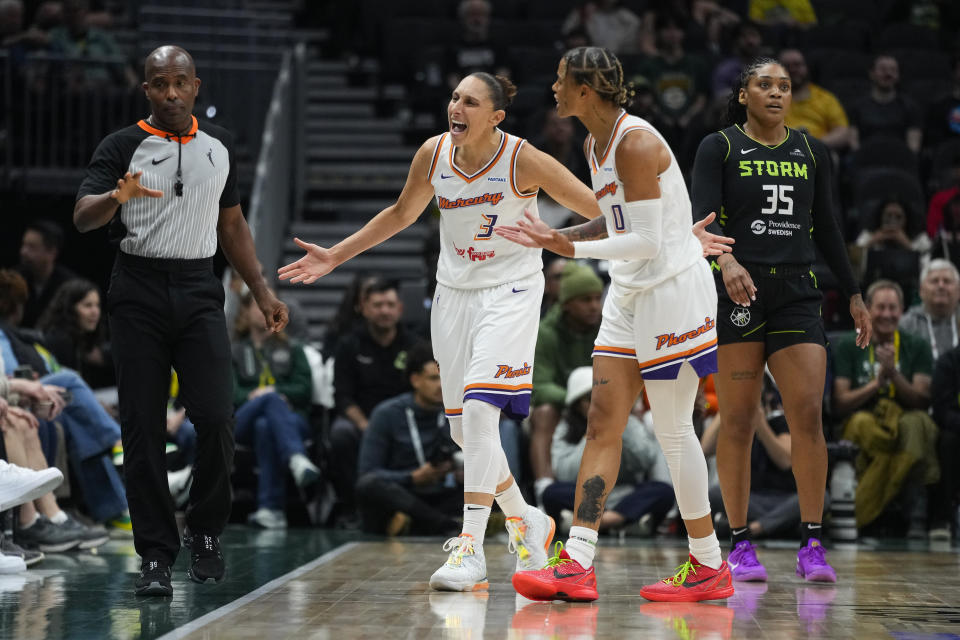 Phoenix Mercury guard Diana Taurasi (3) and guard Natasha Cloud (0) argue a foul call with an official as Seattle Storm guard Victoria Vivians (35) walks past during the first half of a WNBA basketball game Tuesday, June 4, 2024, in Seattle. (AP Photo/Lindsey Wasson)