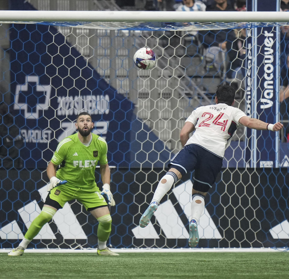 Los Angeles FC goalkeeper Maxime Crepeau, left, prepares to stop Vancouver Whitecaps' Brian White (24) during the second half in Game 2 of a first-round MLS playoff soccer match in Vancouver, British Columbia, Sunday, Nov. 5, 2023. (Darryl Dyck/The Canadian Press via AP)