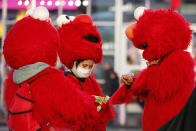 A mask-wearing costumed character in Times Square looks through bills during a lull in activity Thursday, March 12, 2020, in New York. Earlier Thursday, Gov. Andrew Cuomo banned gatherings of 500 or more people. (AP Photo/Kathy Willens)