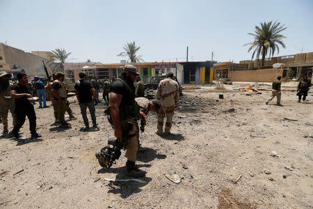 Iraqi security forces gather with Shi'ite fighters in the town of Garma, Iraq, May 26, 2016. REUTERS/Thaier Al-Sudani