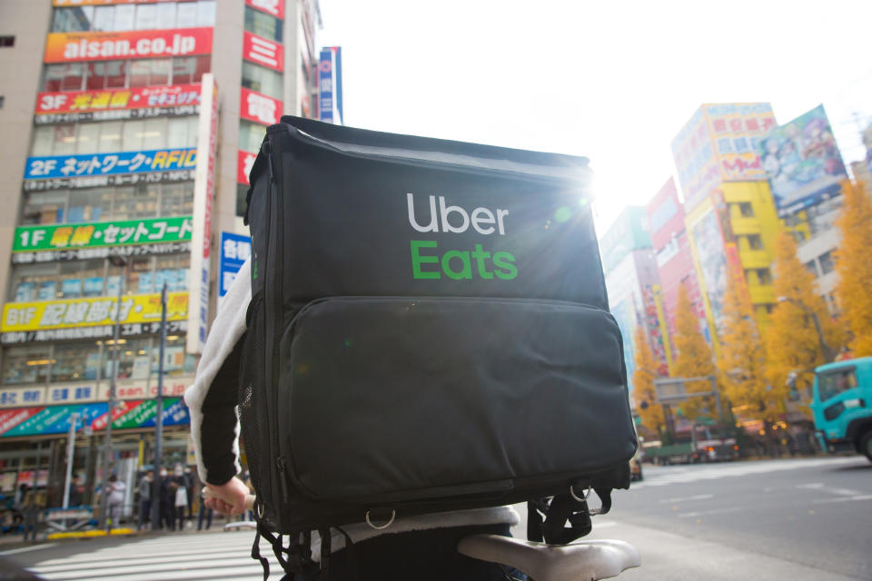 TOKYO, JAPAN - 2019/12/18: An Uber Eats cyclist rides through Chuo-dori Avenue cross road in Akihabara, Tokyo. Akihabara, also called Akiba after a former local shrine, is a district in central Tokyo that is famous for its many electronics shops. In more recent years, Akihabara has gained recognition as the center of Japan's otaku (diehard fan) culture, and many shops and establishments devoted to anime and manga are now dispersed among the electronic stores in the district. (Photo by Stanislav Kogiku/SOPA Images/LightRocket via Getty Images)
