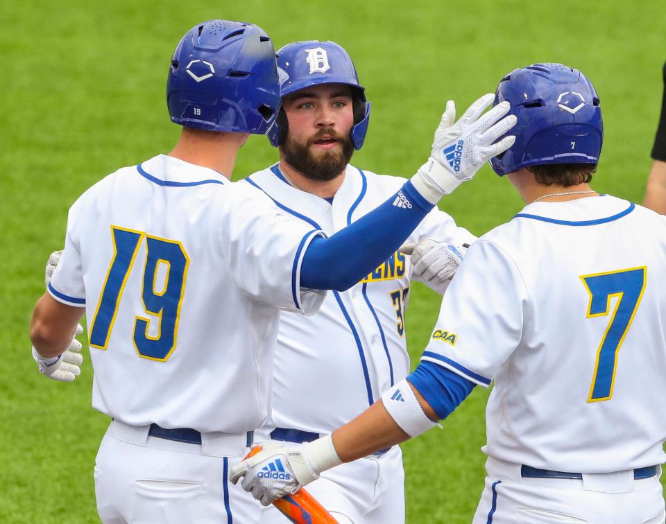 Delaware's Tyler Leach (center) is greeted at home by Brett Lesher (left) and Aidan Kane after hitting a solo home run in the second inning of Rutgers' 15-10 win at Hannah Stadium to start a three-game weekend series in Newark, Delaware, Friday, March 15, 2024.