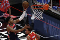 Washington Wizards forward Rui Hachimura (8) lays in a basket over Atlanta Hawks guard Trae Young (11) during the first half of an NBA basketball game Wednesday, May 12, 2021, in Atlanta. (AP Photo/Butch Dill)