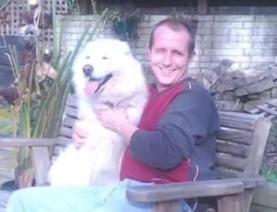 Jason Matthew Perry sits with his former dog, a woolly Siberian named Bell. Perry was struck by a tow truck while helping an injured motorcyclist on Oct. 18, 2023.