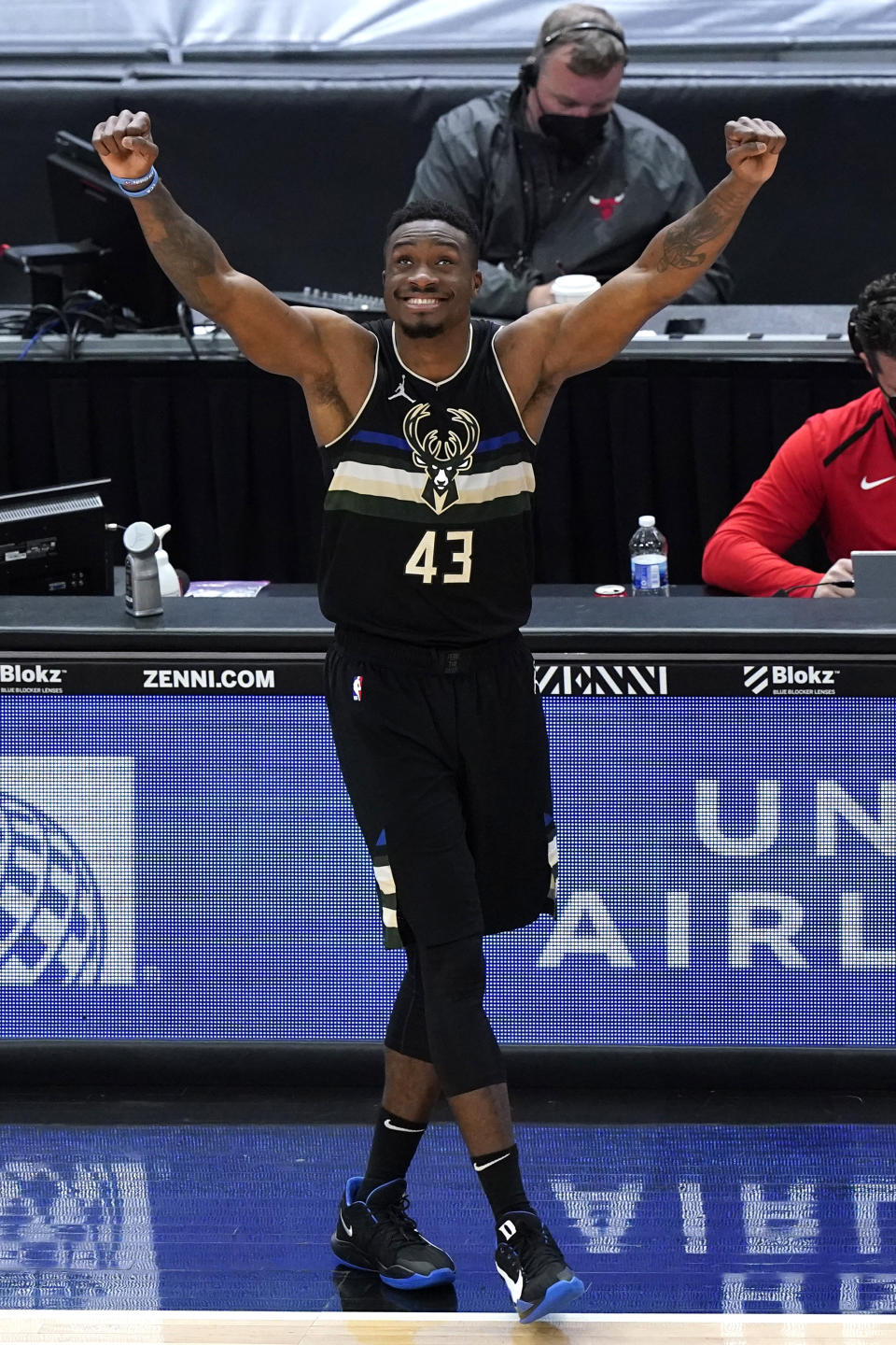 Milwaukee Bucks forward Thanasis Antetokounmpo looks up the score board as celebrates after guard Elijah Bryant scored a basket during the first half of an NBA basketball game against the Chicago Bulls in Chicago, Sunday, May 16, 2021. (AP Photo/Nam Y. Huh)