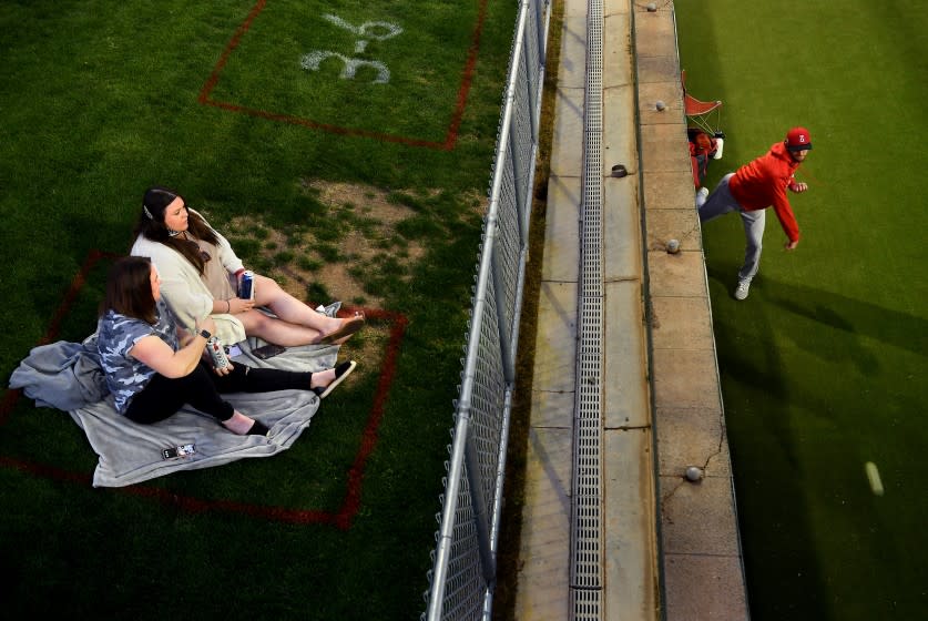 GOODYEAR, ARIZONA MARCH 2, 2021-Fans watch from the outfield as an Angels pitcher warms-up in the bullpen during a game against the Reds at spring training in Goodyear, Arizona Tuesday. (Wally Skalij/Los Angeles Times)