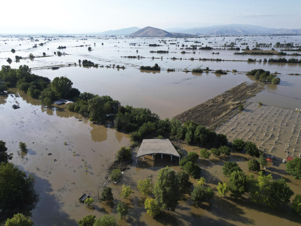 FILE - Floodwaters and mud cover the plain in the town of Palamas, after the country's rainstorm record, in Karditsa, Thessaly region, central Greece, on Sept. 8, 2023. The storms flooded 720 square kilometers (72,000 hectares), mostly prime farmland, totally destroying crops. They also swamped hundreds of buildings, broke the country's railway backbone, savaged local roads and bridges and killed tens of thousands of livestock. Thessaly accounts for about 5% of national economic output, and a much larger proportion of agricultural produce. (AP Photo/Vaggelis Kousioras, File)