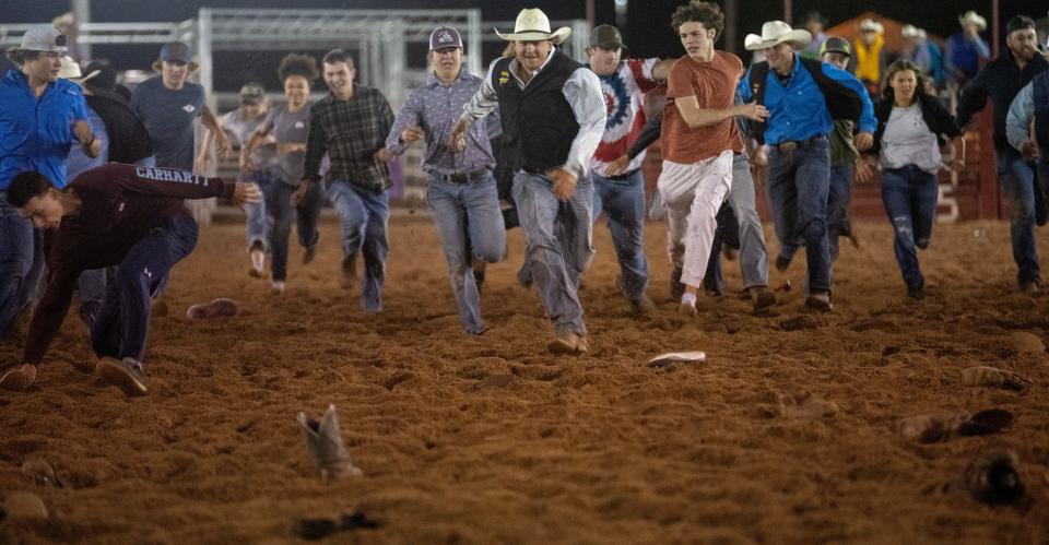 In the college boot scramble, students race to find their boot in a pile at the end of the arena and get back to the finish line first.