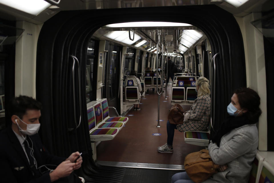 People, wearing the compulsory face mask, sit in a subway train Monday, May 11, 2020 in Paris. The French began leaving their homes and apartments Monday for the first time in two months without permission slips as the country began cautiously lifting its virus lockdown. (AP Photo/Rafael Yaghobzadeh)