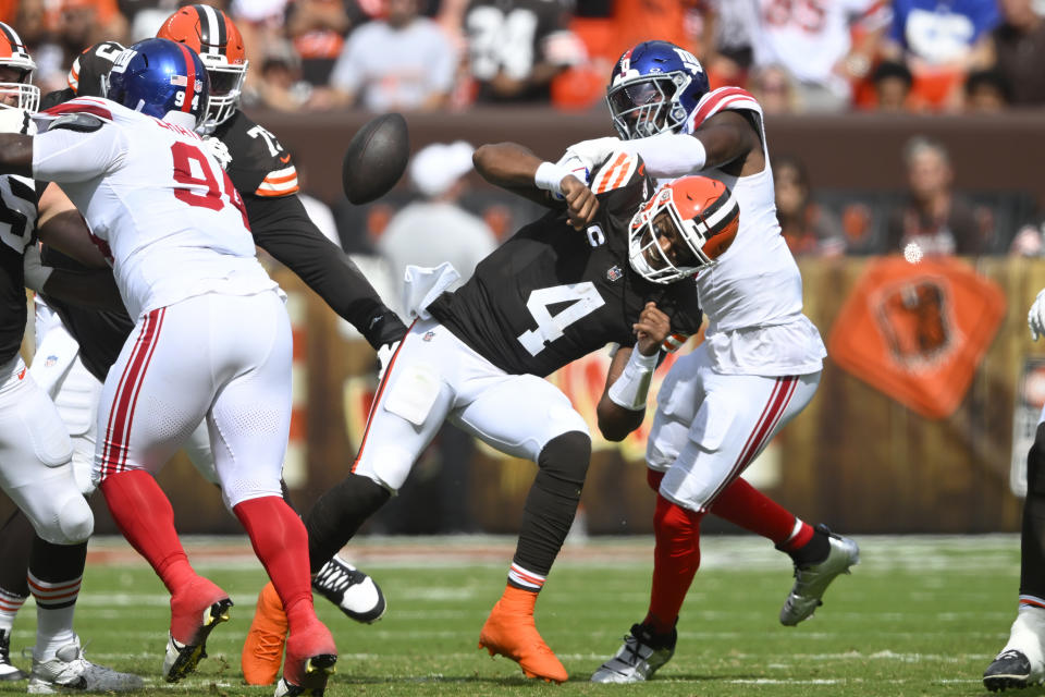 New York Giants linebacker Brian Burns, right, forces Cleveland Browns quarterback Deshaun Watson (4) to fumble the ball, which the Giants recovered, during the first half of an NFL football game, Sunday, Sept. 22, 2024 in Cleveland. (AP Photo/David Richard)